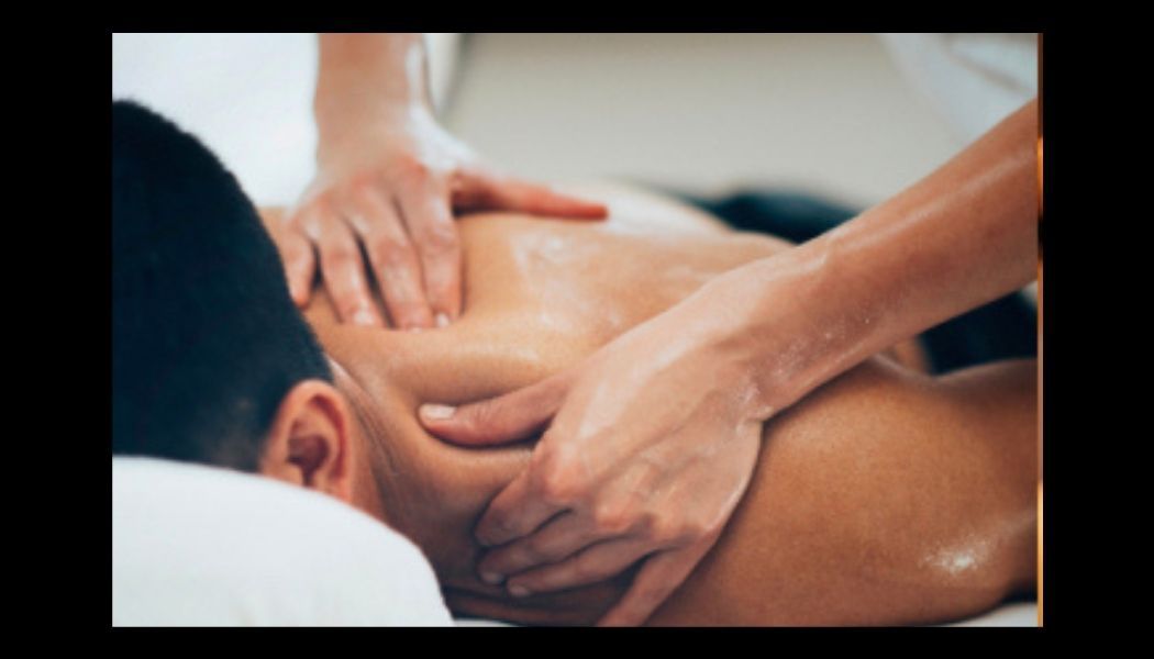 Mains délicates appliquant une huile de massage dans une lumière douce